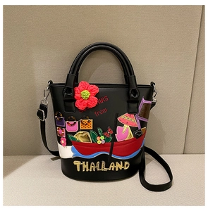 Detail of Thailand themed bucket bag with colorful floral embroidery and souvenirs motif