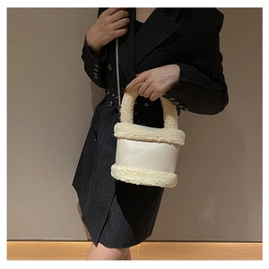 Close-up of cream white plush bucket bag featuring soft faux fur and elegant silver chain