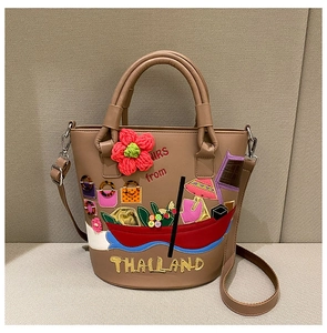 Detail of khaki bucket bag with colorful Thai embroidery, 3D flowers and strap
