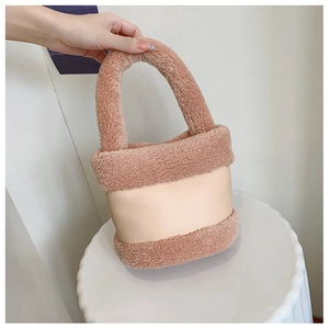 Détail du sac seau en peluche avec finitions en cuir et poignée épaisse en fourrure