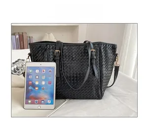 Detail der schwarzen geflochtenen Ledertasche zeigt großes Fassungsvermögen mit iPad
