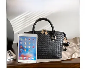 Détail du sac à main en cuir tressé noir avec une tablette pour comparer la taille