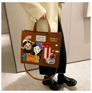 Detail of a brown leather tote with British embroidery, seen on a model for size scale