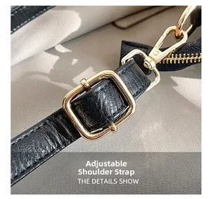 Détail de la bandoulière réglable en cuir noir grainé avec boucles en métal doré clair