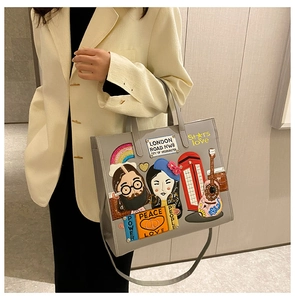 Detail view of grey tote bag featuring colorful London-themed embroidery and patches