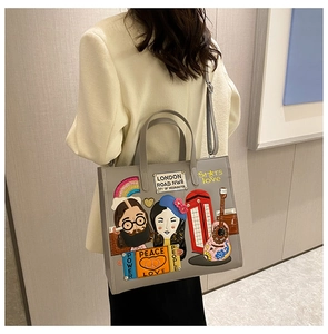 Detail of grey tote bag featuring colorful patch embroidery with London and art motifs
