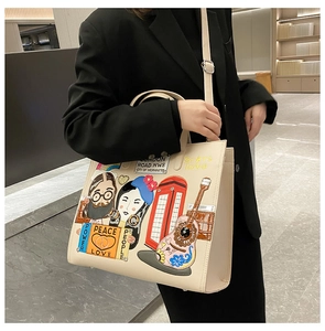 Detail of off-white leather tote bag featuring pop art embroidery and patchwork design