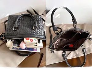 Détail de l'intérieur d'un grand sac tissé noir montrant sa capacité pour tablette et objets