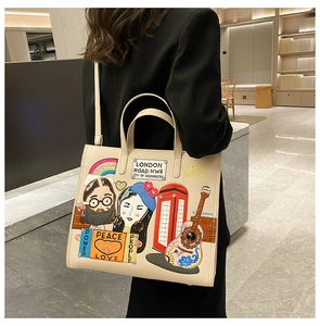 Detail of cream tote bag with London-themed embroidery and patchwork on black blazer