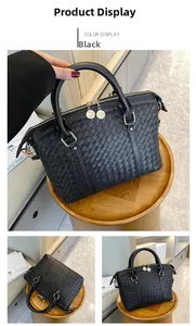 Détails du sac Boston noir tissé avec doubles fermetures éclair dorées et poignées en cuir