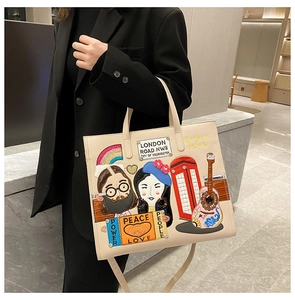 Detail of beige tote bag featuring London street theme embroidery and colorful patches
