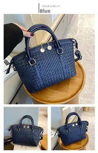 Détail du sac cabas tressé bleu marine avec fermeture dorée posé sur un tabouret en bois