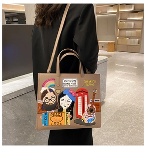 Detailed close-up of khaki tote bag featuring colorful embroidery patches and art motifs