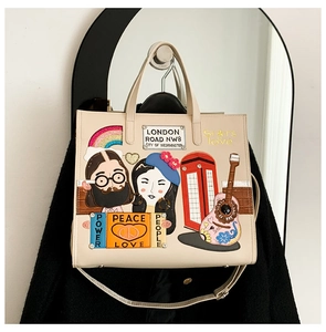 Close-up of pop art embroidery with British telephone booth and guitar on cream tote bag
