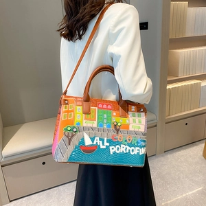 Portofino style embroidered handbag featuring colorful coastal architecture and brown handles