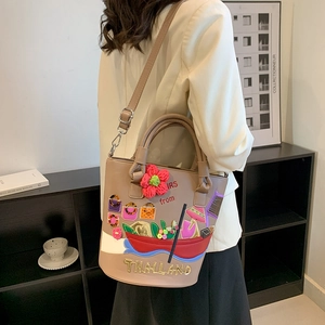 Vintage khaki leather bucket bag with floral embroidery and Thailand themed patches