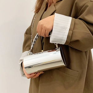 Sac cylindrique argenté brillant avec bandoulière en chaîne et poignée métallique