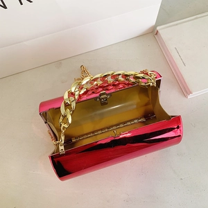 Sac cylindre rose métallisé avec bandoulière chaîne dorée et fermoir en métal brillant