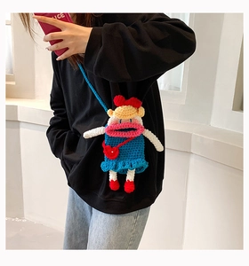 Sac bandoulière fait main au crochet avec robe bleue et nœud rouge porté par mannequin