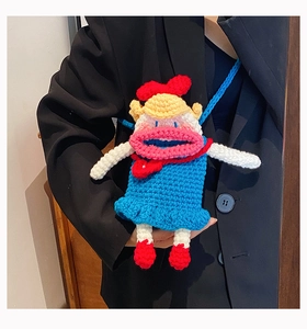 Détail d'un sac bandoulière fait main au crochet avec une grande bouche rouge et un nœud