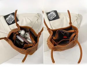 Detailed view of brown woven handbag interior showing large main compartment and inner pocket