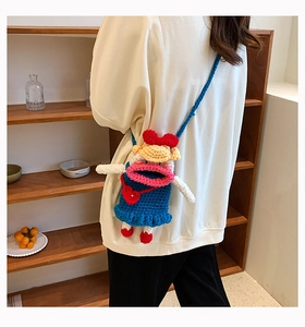 Détail d'un sac à bandoulière au crochet fait main avec visage rigolo et sangle bleue