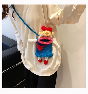 Détail d'un sac poupée au crochet bleu avec cheveux jaunes et grosses lèvres roses