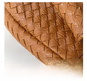 Detailed close-up of premium woven leather texture and precise stitching on brown handbag
