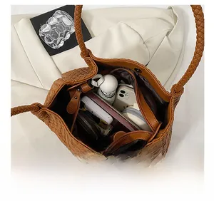 Detailed interior of a brown woven leather tote bag showing spacious capacity for daily items