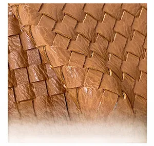 Close-up of the woven brown leather texture and premium craftsmanship on the shoulder bag