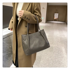 Macro shot of metallic grey woven leather tote bag with Intrecciato pattern detail