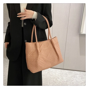 Detail of hand-woven peach tote bag showing the intricate intrecciato leather texture