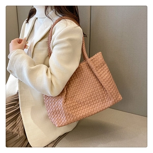 Detailed close-up of pink woven leather tote bag with large cross-weave texture
