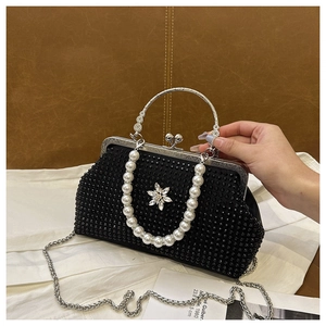 Gros plan du sac de soirée noir à strass avec boucle fleur argentée et anse en perles
