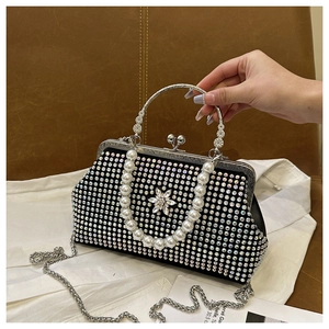 Détail d'une pochette de soirée noire en strass avec décor floral et poignée en perles