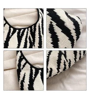 Dettaglio della borsa in maglia zebrata con texture spessa e bordo rifinito in nero