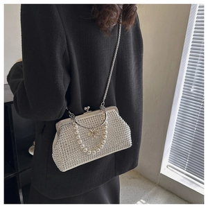 Détail de la poignée en perles et strass d'une pochette de soirée vintage blanche