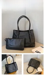 Close-up of black woven tote bag and matching zippered pouch with textured finish