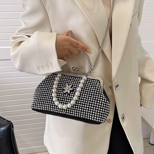Détail de pochette de soirée en velours noir avec strass, perles et fermoir fleuri
