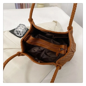 Detail view of woven tote bag interior showing zipper compartment and brown lining