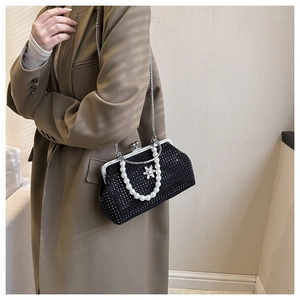 Détail du sac de soirée noir à strass avec poignée en perles et ornement floral en cristal
