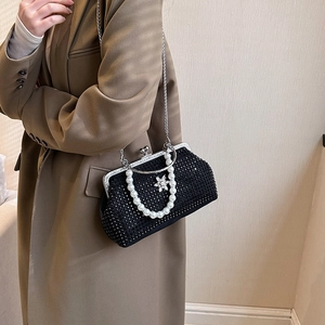 Détail de la pochette de soirée en strass noirs avec poignée en perles sur le modèle