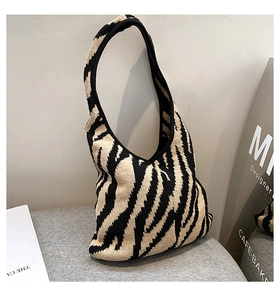 Dettaglio della borsa a spalla in maglia con strisce zebrate e forma hobo a mezzaluna