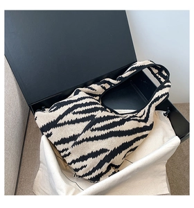 Dettaglio borsa in maglia con motivo a onde zebra in una scatola regalo nera