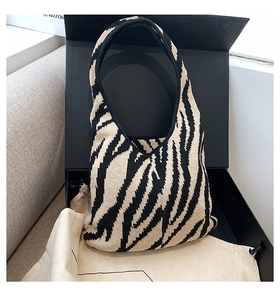 Dettaglio borsa in maglia zebrata con confezione regalo di lusso e sacchetto antipolvere