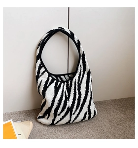 Dettaglio della borsa tote in maglia zebrata con tracolla integrata in stile minimal