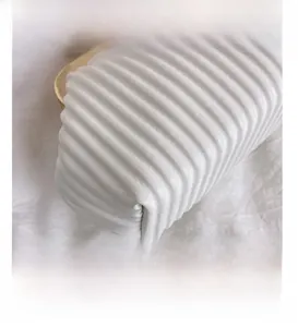 Detail of white pleated handbag featuring wavy texture and elegant gold metal frame
