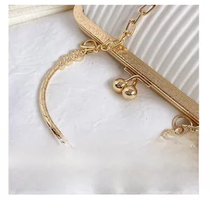 Detail view of gold vintage clasp and white pleated fabric on a luxury evening bag