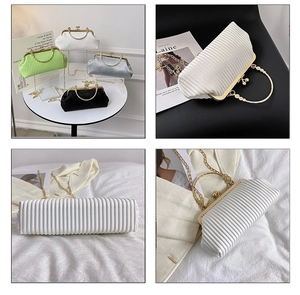 Detail of pleated evening clutches with golden ring handles and chic metal chains