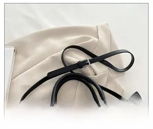 Détail de la bandoulière réglable sur un sac à main noir orné de broderies colorées